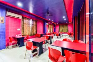 Un restaurante con sillas y mesas rojas en una habitación. en Hotel O ShamRock INN, en Jaipur