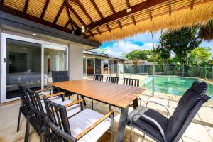 comedor con mesa, sillas y piscina en Broadbeach Canal Front Getaway with Pool & Jetty, en Gold Coast