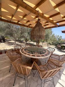 a patio with a table and chairs under a roof at Siren Village Living in Kallepia +8 photos
