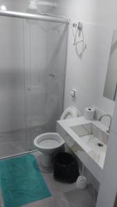 a bathroom with a toilet and a glass shower at Hotel Marques in Coração de Jesus
