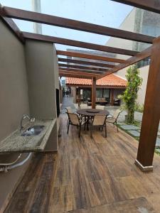 un patio con tavolo e sedie in cima a un edificio di Casa pé na areia na Praia de Juquehy a São Sebastião Altre 42 foto