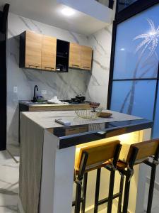 a kitchen with a counter and two bar stools at Casa campestre con piscina privada in Villeta
