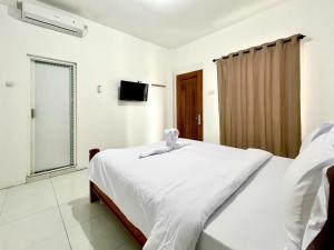a bedroom with a bed and a television in it at Sazara Hotel Batu in Selecta