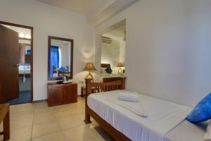 a bedroom with a bed and a desk and a mirror at Mount Marina Villas - HAZEL in Galle