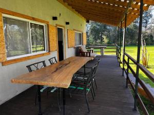 a wooden table and chairs on a deck at Isla La Scaloneta in Estación Delta