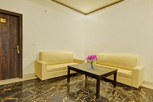 una sala d'attesa con due sedie e un tavolo con fiori di Super Collection O Mountain View Resort a Rānchī Altre 34 foto