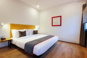 Un dormitorio con una cama grande en una habitación de hotel. en Super Townhouse RCC Elite, en Hyderabad
