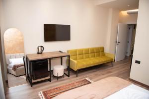 a living room with a yellow couch and a table at Ora E Vjeter in Vlorë