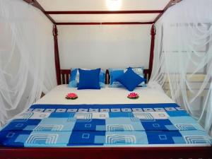a bed in a tent with blue and white pillows at Room No2 in Galle