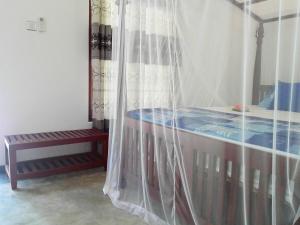 a bedroom with a canopy bed and a bench at Room No2 in Galle +5 photos