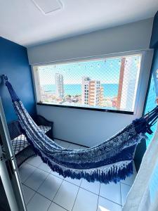 - un hamac dans une chambre avec fenêtre dans l'établissement Apartamento Casa Praiana - 200m do mar, com vista, à Fortaleza