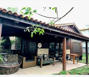 a pavilion with a table and chairs on a patio at PRAIA DA FERRUGEM PÉ NA AREIA PRÓXIMO ao MAR, GAROPABA in Garopaba