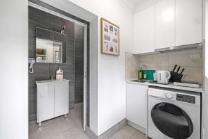 a kitchen with a washing machine and a sink at No Frill Economic Double Room - Ideally Located - Shared External Bathroom & Kitchen in Sydney