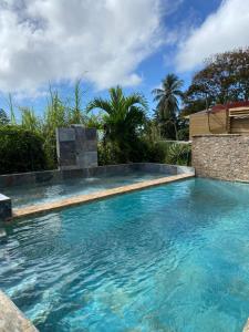 a swimming pool with blue water in a yard at Gîtes La Troisième Chute in Capesterre-Belle-Eau