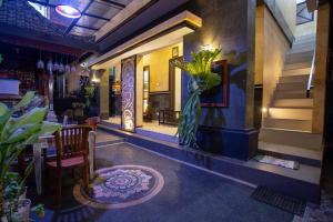 jadalnia ze stołem i wazonem kwiatów w obiekcie Kubu Indah Homestay Sanur w mieście Sanur