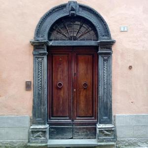 a wooden door with an arch in a building at Casa 28 Luglio-RADICI in Mercatello sul Metauro +7 photos