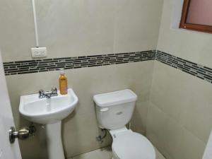 a bathroom with a toilet and a sink at Amplio departamento para grupo de 10 personas con 3 dormitorios in Cuenca +10 photos