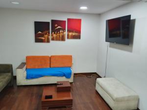 a living room with a couch and a flat screen tv at Amplio departamento para grupo de 10 personas con 3 dormitorios in Cuenca