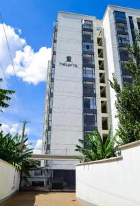 a tall white building with a sign on it at Niva house in Ruaka