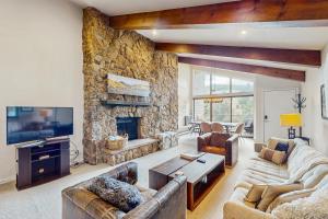 a living room with couches and a stone fireplace at Beaver Creek West 22 in Avon