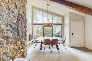 a dining room with a stone wall and a table and chairs at Beaver Creek West 22 in Avon