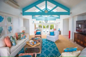 a living room with a couch and a tv at Middle Cay Estate estate in Harbour Island