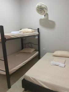 a room with two bunk beds and a fan at Tres Palmas apartamento - Carmen de apicalá in Carmen de Apicalá