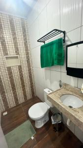 a bathroom with a toilet and a sink at Casa com dois quartos e piscina in Barreirinhas +13 photos