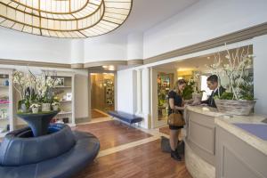 a man and woman standing at a counter in a salon at Cristal Hôtel & Spa in Cannes