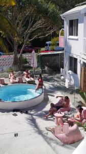 a group of people sitting around a swimming pool at CALI Backpackers in Caloundra