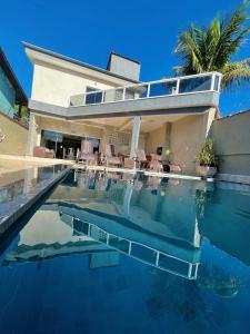 una casa con piscina delante en Casa de praia com piscina, en Guarujá