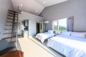 a hotel room with two beds and a staircase at Gaon Resort Byeongsan in Buan