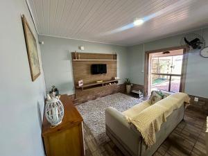 a living room with a couch and a tv at Casa de Praia da Família Martins in Tramandaí