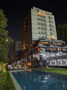 a hotel with a swimming pool in front of a building at Departamento Resort zona aeropuerto in Luque