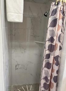 a shower with a shower curtain in a bathroom at western skies motel in Clarendon +3 photos