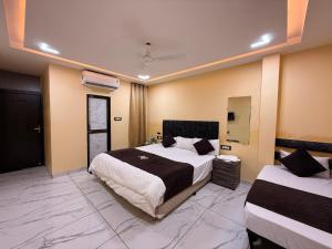 a large bedroom with two beds in a room at Hotel Roshan in Ujjain