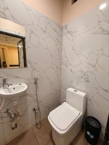 a bathroom with a white toilet and a sink at Hotel Roshan in Ujjain