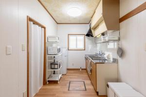 a small kitchen with a sink and a stove at Niko House Furano in Furano