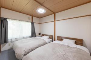 a bedroom with two beds and a window at Niko House Furano in Furano