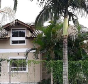 eine Palme vor einem Haus in der Unterkunft Pedra Branca Villa Hostel in Barra Velha