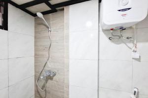 a shower in a bathroom with a shower head at Urbanview TeBeYe Syariah UNS Solo in Solo