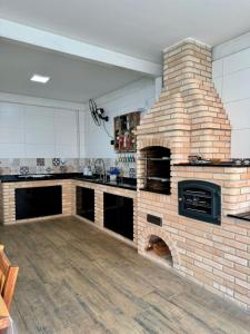 eine Küche mit einem Backsteinofen in der Mitte in der Unterkunft Casa Azul da Bocaina em São José do Barreiro in São José do Barreiro