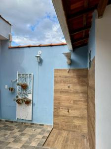 ein Haus mit einer blauen Wand und einer Holztür in der Unterkunft Casa Azul da Bocaina em São José do Barreiro in São José do Barreiro