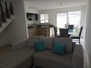 a living room with a couch and a kitchen at Hermosa casa en cluster privado in Laurel de Lagunillas