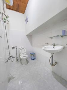 a bathroom with a toilet and a sink at Lucia Home Đà Lạt in Da Lat