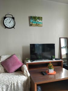 Punta Engaño3 BRooms 3 Baths Cozy Condo, One Manchester Place的客厅里有一台电视，墙上挂着一只钟