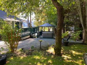 einen Hinterhof mit einem Pavillon und einem Baum in der Unterkunft Mile 77 Cottages in Youbou