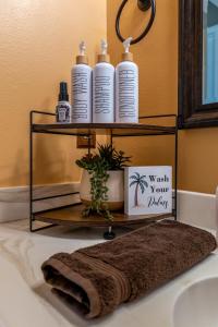 a bathroom sink with three bottles of soap on a shelf at Jt Desert Dwelling in Twentynine Palms