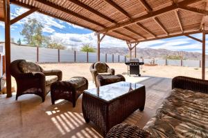 a patio with chairs and a table and a fireplace at Jt Desert Dwelling in Twentynine Palms