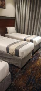 a group of three beds in a hotel room at محبس الجن in Al Khansāk